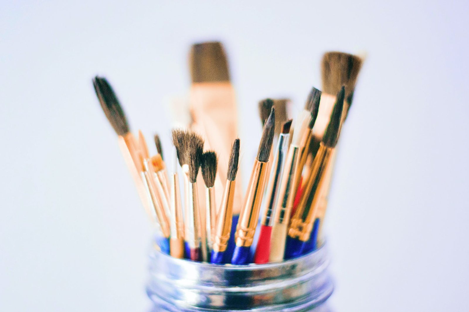 shallow photography of brushes on jar